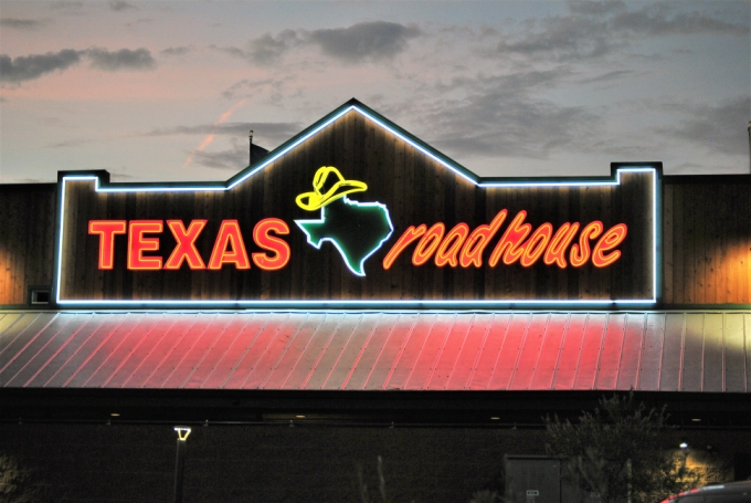Illuminated neon restaurant sign at dusk