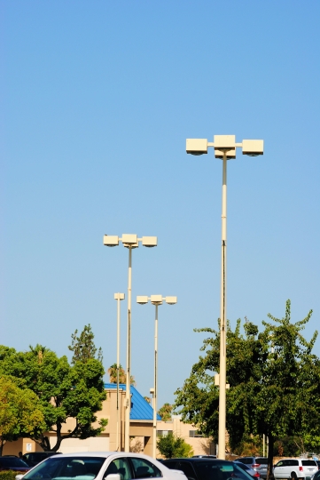 Parking lot pole lights against a blue sky